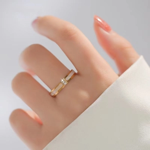 Eleganter Ring aus Roségold-Titanstahl mit weißer Muschel-Einlage und zwei funkelnden Diamanten