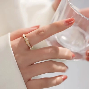 Detailansicht eines roségoldenen Titanrings mit weißer Einlage und kleinem Diamanten