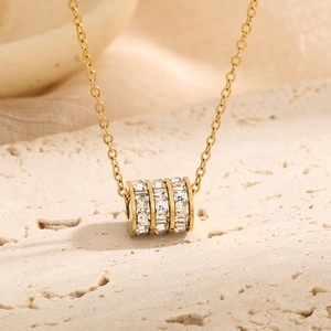 Macro shot of gold cylinder pendant with square zircon crystals on O-chain necklace
