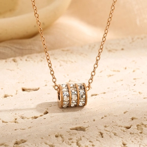 Rose gold titanium necklace with a triple-row zircon cylinder pendant on stone background
