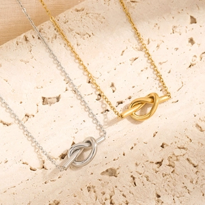 Minimalist knot pendant necklace in gold and silver finish on textured stone