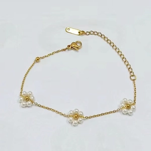 Detail of gold flower chain necklace with three small white pearl blossoms and clasp