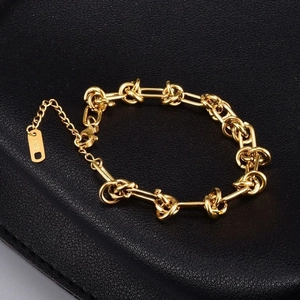 Detailed close-up of gold chain bracelet with knot links and K18 engraving on the tag