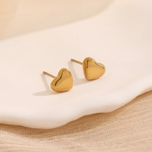Ensemble de boucles d'oreilles cœur en or poli sur un plateau au style minimaliste doux