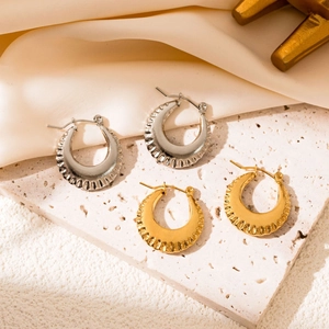 Detail of ribbed hollow hoop earrings in gold and silver finish on silk fabric