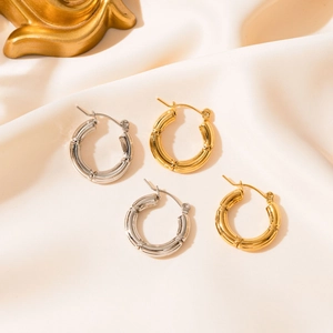 Set di orecchini a cerchio texture bambù in oro e argento su tessuto di seta