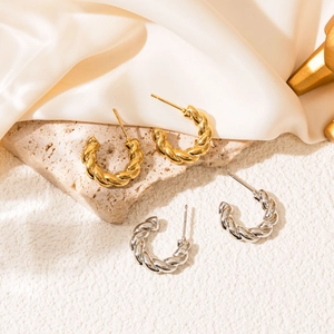 Detail of twisted rope texture on gold and silver stainless steel C-shaped earrings