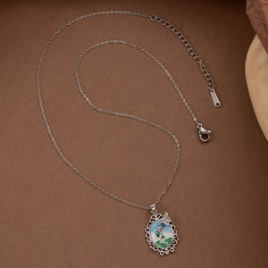 Collier en acier inoxydable argenté avec pendentif floral ovale et détail papillon