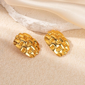 Gold titanium steel earrings with geometric texture on elegant silk background