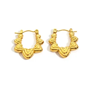 Detail of 18K gold-plated stainless steel hoop earrings featuring small 3D heart shapes