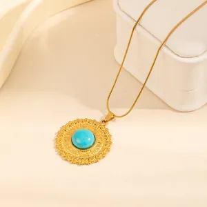 Vintage gold necklace featuring a round turquoise sunburst pendant on a jewelry box