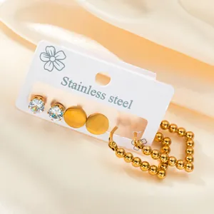 Three-pair gold stainless steel earring set with zircon studs and beaded hoop on satin