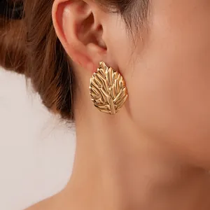 Makro-Detail eines goldenen Blattohrrings mit feiner Textur und eleganter 18K-Vergoldung