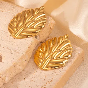 Makro-Detail von goldfarbenen Blatt-Ohrringen mit realistischer Aderstruktur und Politur