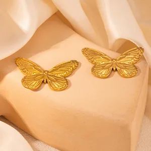 Detailansicht von zwei goldenen Schmetterling-Ohrsteckern mit strukturierter Textur