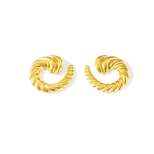 Makro-Detail goldener Titanstahl-Ohrringe mit Spiraltextur und gewelltem Finish