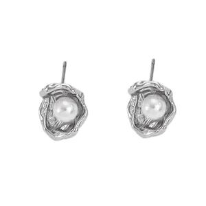 Detailed view of silver minimalist stud earrings with baroque pearl in shell design
