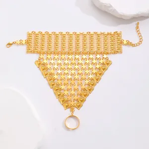 Detailed view of golden slave bracelet with heart accents and woven texture