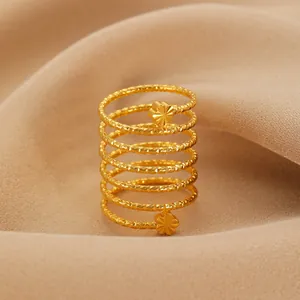 Macro shot of gold spiral ring with flower details on smooth beige satin fabric