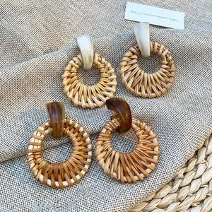 Bohemian round rattan earrings with marble and amber resin studs on a burlap background
