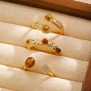 Macro shot of gold-plated three-piece ring set with tiger eye stones and diamonds