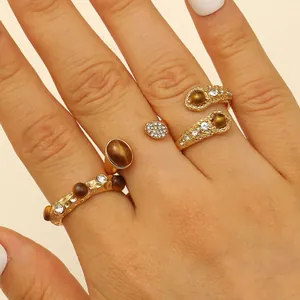 Close-up of bohemian gold rings set with brown tiger eye stones and white crystals