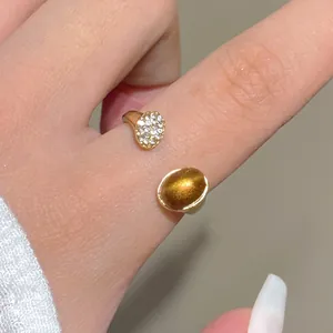 Detail of an open gold ring featuring tiger eye stone and shimmering crystal zirconias