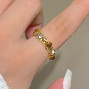 Macro shot of gold hammered ring with brown tiger eye stones and sparkling crystals