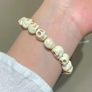 Détail d'un bracelet de perles de crâne blanc de style gothique punk au poignet