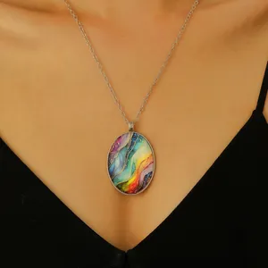 Detail van ovale regenbooghanger met artistieke harskunst en fonkelende gouden vlokken