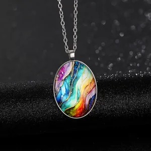 Detail van de ovale glazen hanger ketting met kleurrijke abstracte kunst en zilveren ketting