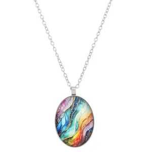 Detail van de zilveren ovale hanger met kleurrijke abstracte kunst en fijne ketting