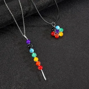 Detailopname van kleurrijke chakra steen hangers op een zwarte matte achtergrond