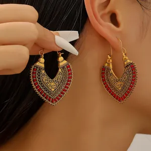 Bohemian vintage hollow heart earrings in gold finish with red woven cord detail