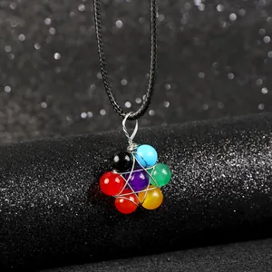 Detail van handgemaakte zeven chakra stenen hanger ketting met draadgewikkeld bloemmotief