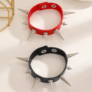 Vue détaillée des bracelets punk en cuir rouge et noir avec pointes métalliques et boutons-pression