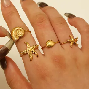 Set of four 18K gold plated stainless steel open rings with starfish and seashell charms
