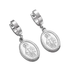 Gros plan sur des boucles d'oreilles religieuses en acier avec pendentifs Vierge Marie