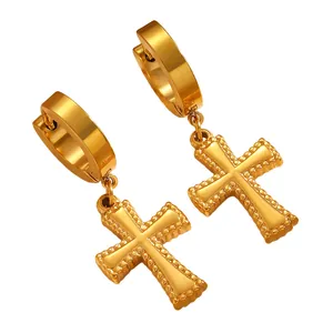 Boucles d'oreilles créoles dorées en acier avec pendentifs croix sur fond blanc