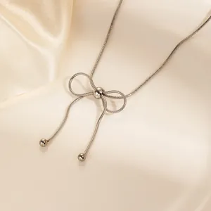 Dettaglio di una collana a catena serpente d'argento con fiocco e nappe di perline