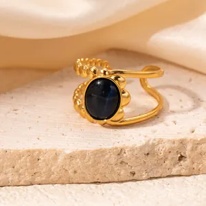 Detailed view of an 18K gold plated open ring featuring an oval cat-eye stone and beaded band