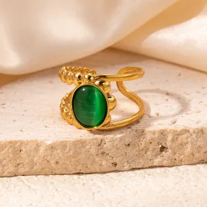 Macro shot of gold vintage open ring featuring a green cat-eye stone and beaded texture