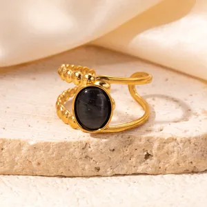 Detailed macro of gold-plated titanium steel ring with black cat-eye stone on stone base