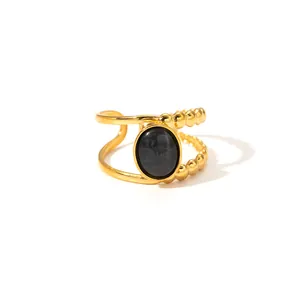 Detail of gold open ring with black oval stone and double-layer beaded metal band