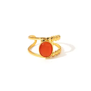 Detailed macro of gold dual-layer open ring featuring a smooth band and beaded chain with red stone