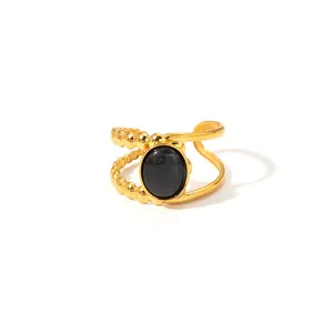 Detailed macro view of the gold-tone asymmetric ring with black stone and beaded texture