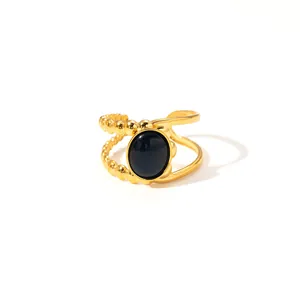 Detailed macro view of the double-layered golden ring featuring a black oval stone inlay