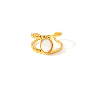 Detail of gold-plated titanium ring with asymmetric bead bands and oval white stone