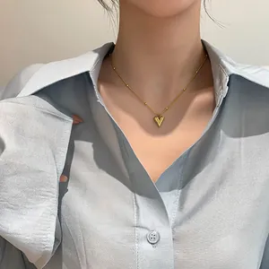 Collier cœur doré minimaliste avec chaîne à billes porté par un mannequin pour un look chic
