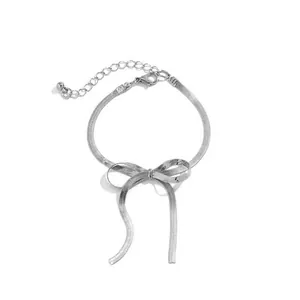 Detail eines silbernen Schlangenkette-Armbands mit eleganter Schleife und Karabinerverschluss